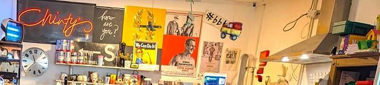 The back wall: a neon 'Chinty's' sign, a chalkboard asking 'how are you?', vintage posters, a clock and shelves